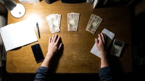 パパ活の費用の内訳を男性が机の上で仕分ける様子