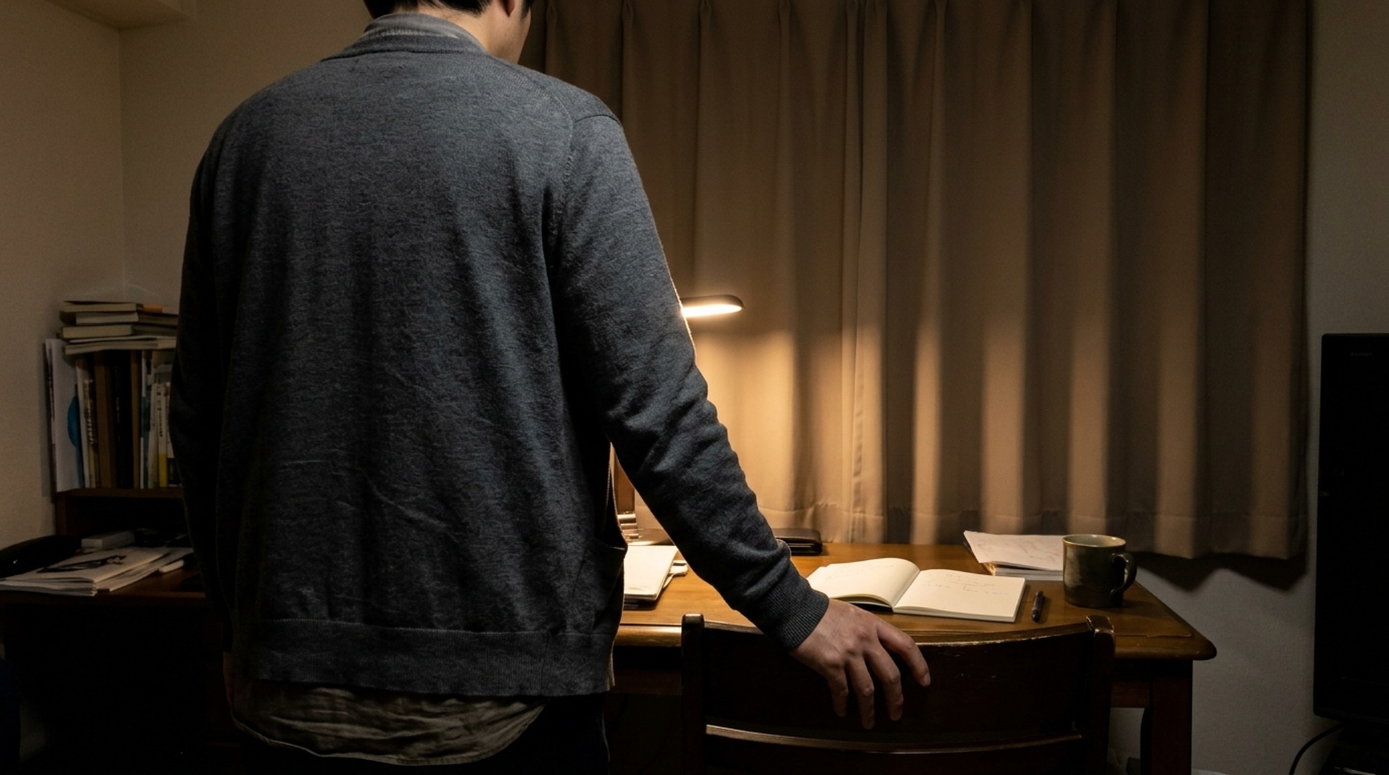 シュガーダディとペイターズのどちらが向くかを夜の書斎で考える男性の後ろ姿