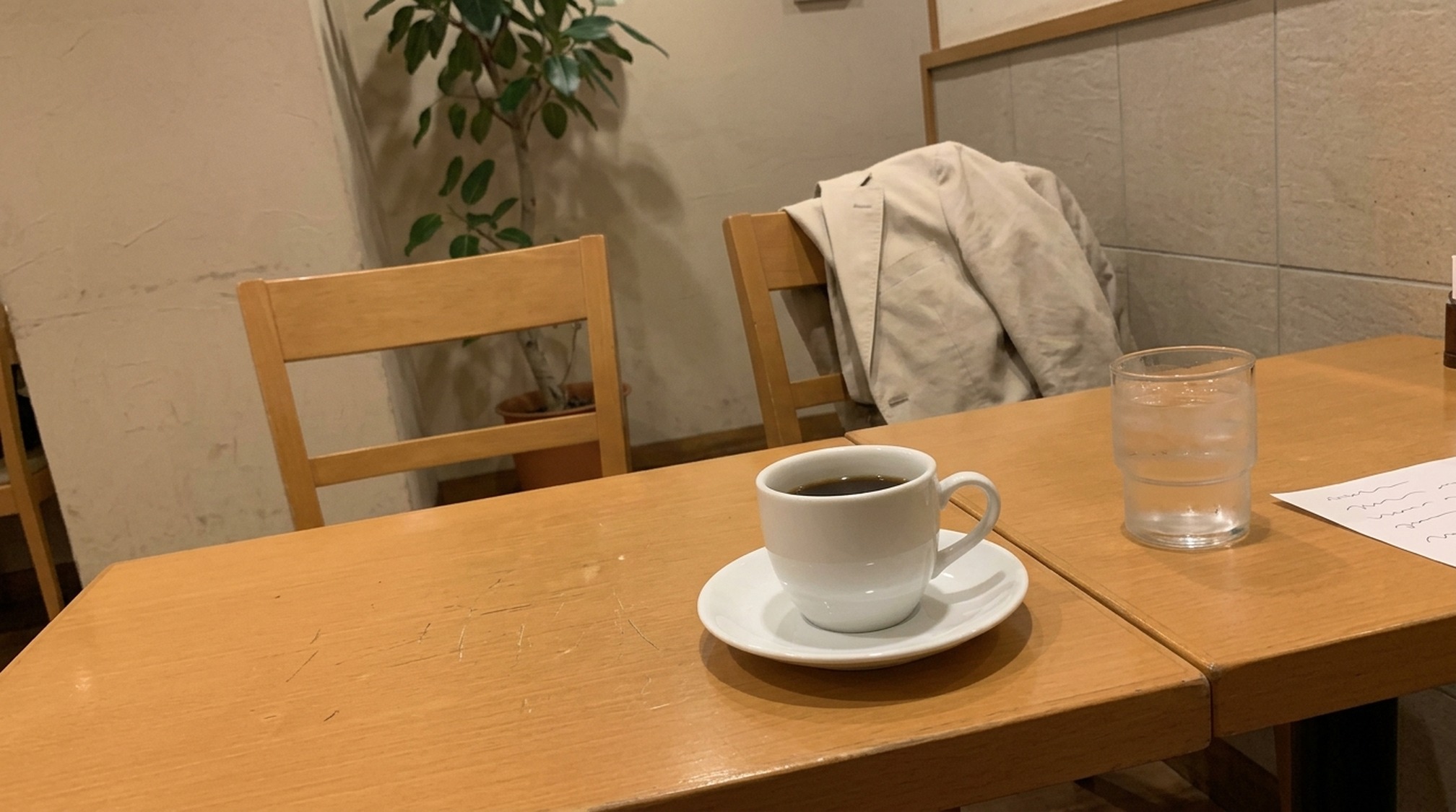 場面別のパパ活の服装を考えるカフェの席と椅子にかけた夏ジャケット
