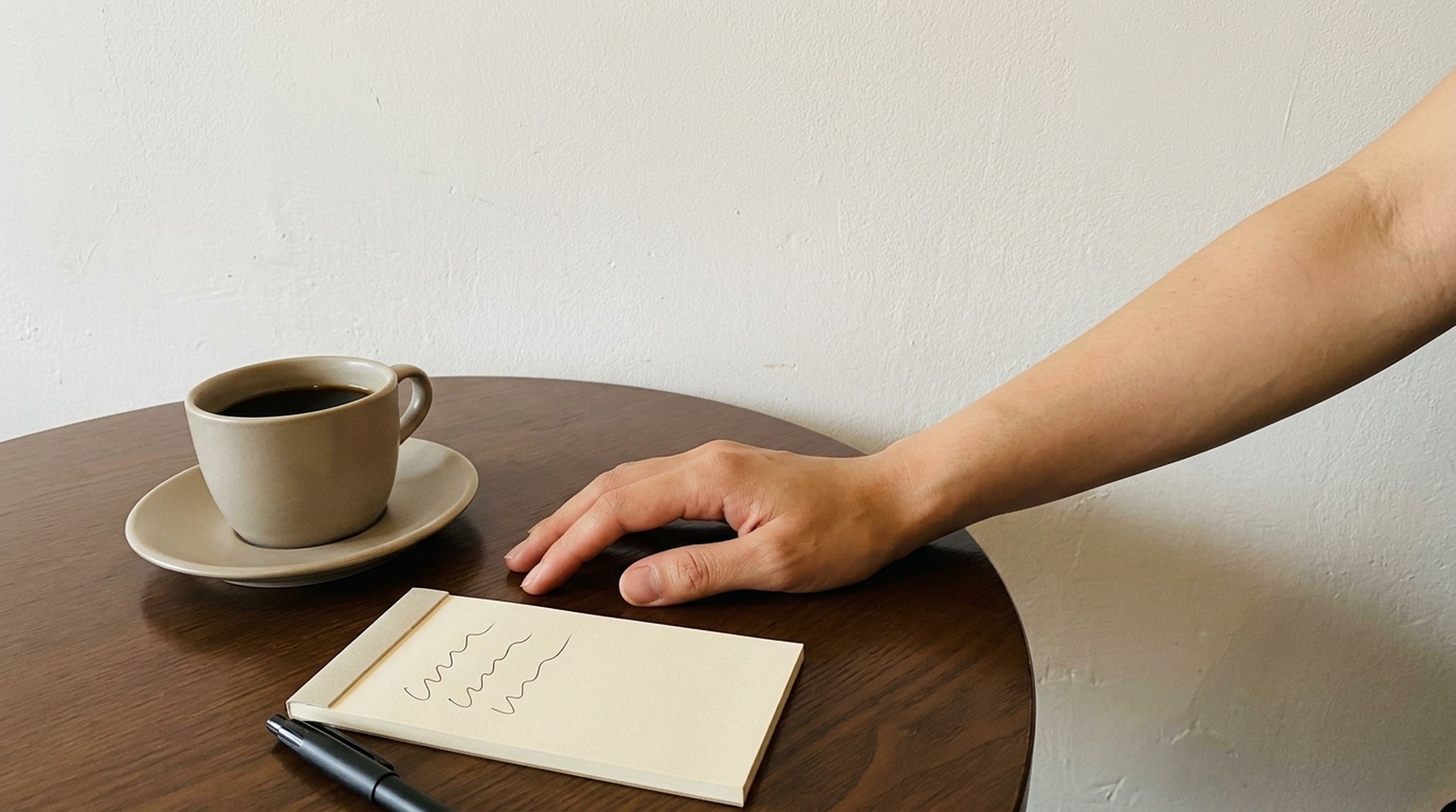 パパ活の定期の相場についての疑問を書き出したメモとコーヒー